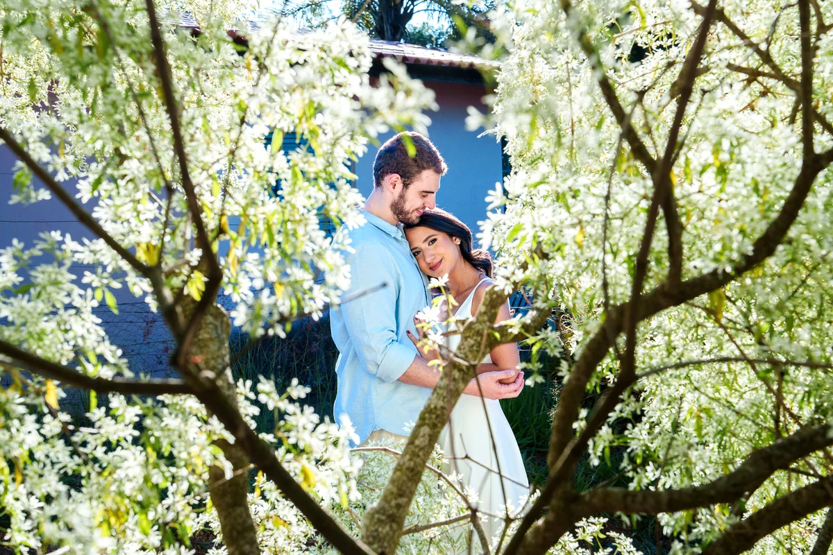 Ensaio do casal entre flores brancas